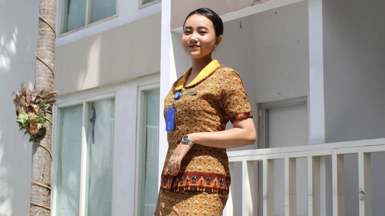 Sekolah Pramugari Di Jakarta. Wanita muda Indonesia tersenyum mengenakan seragam batik.