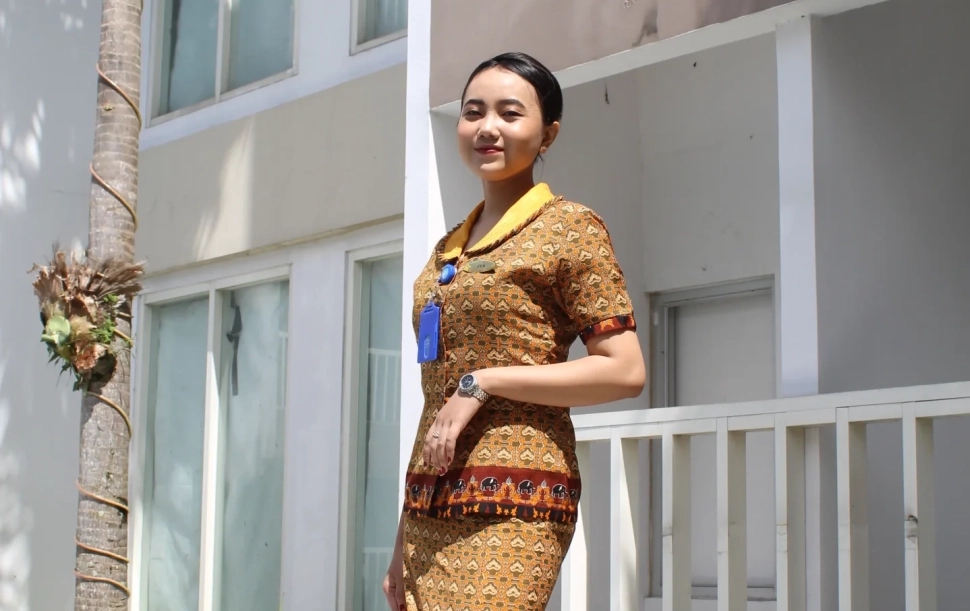 Sekolah Pramugari Di Jakarta. Wanita muda Indonesia tersenyum mengenakan seragam batik.